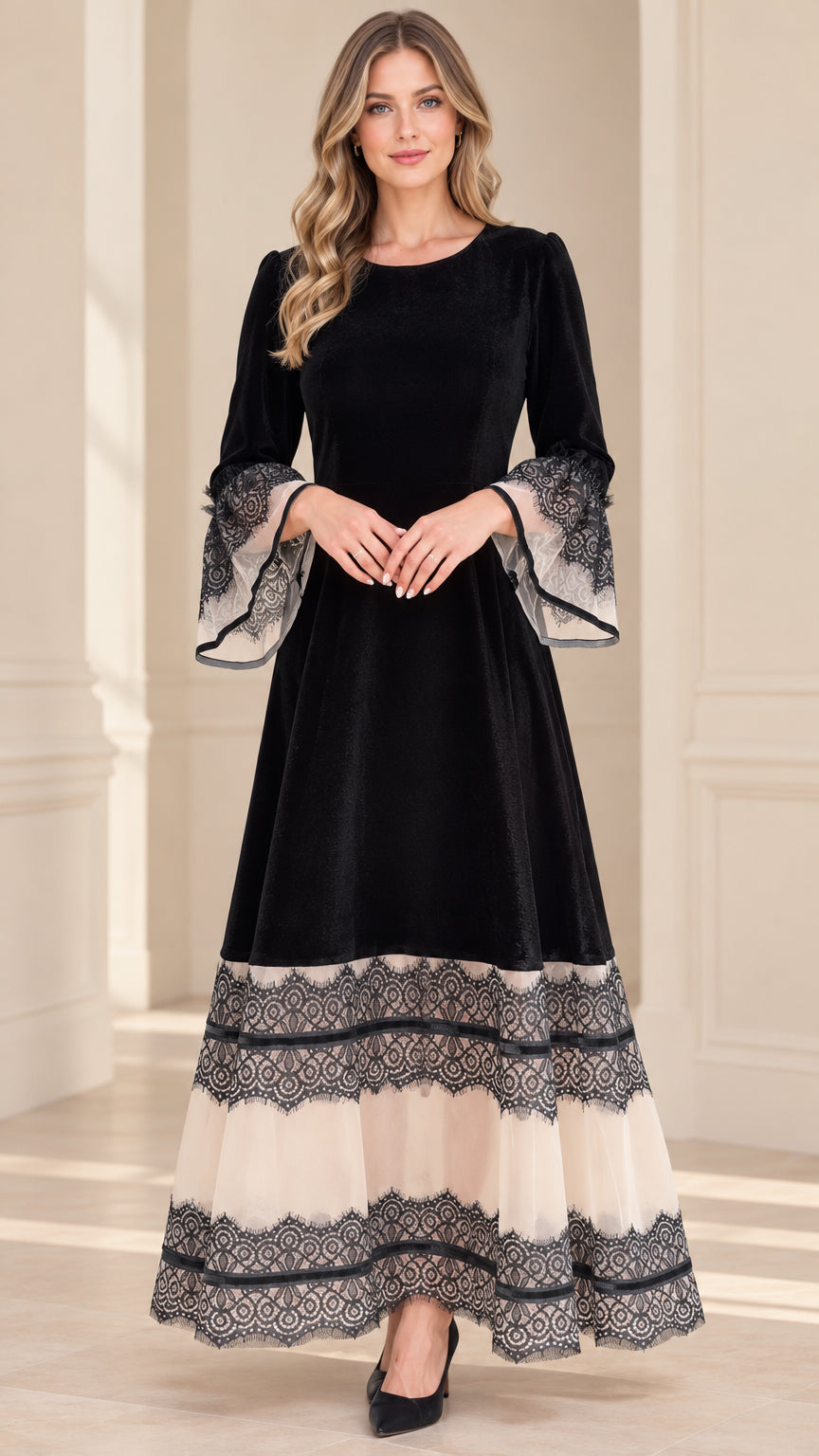Front view of model wearing black velvet maxi dress with tiered lace hem and bell sleeves