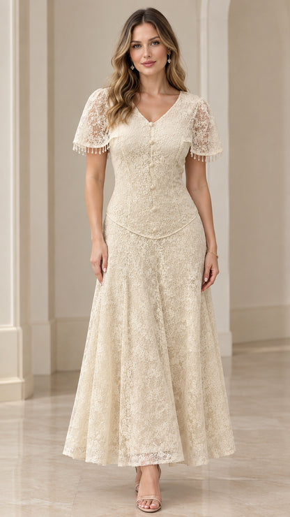 Front view of woman wearing champagne floral lace V-neck maxi dress with beaded flutter sleeves