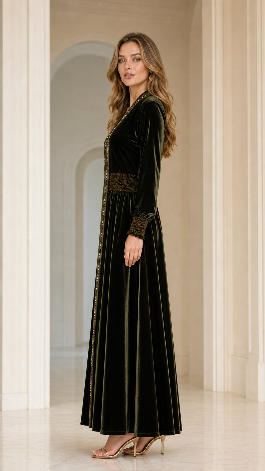 Side profile view of model in Dark Green velvet kaftan dress with smocked waist