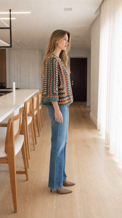 Side profile view of woman modeling colorful crochet knit cardigan with 3/4 sleeves
