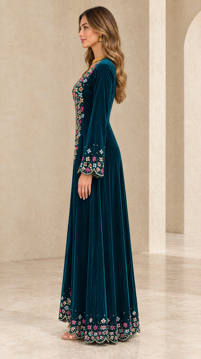 Side profile view of teal velvet long sleeve embroidered gown