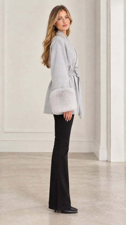 Side profile view of model wearing grey belted faux fur cuff jacket