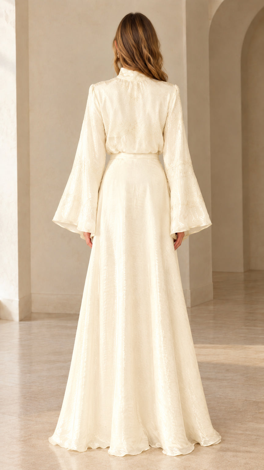 Back view of woman wearing ivory long sleeve maxi dress showing fitted back and flared skirt
