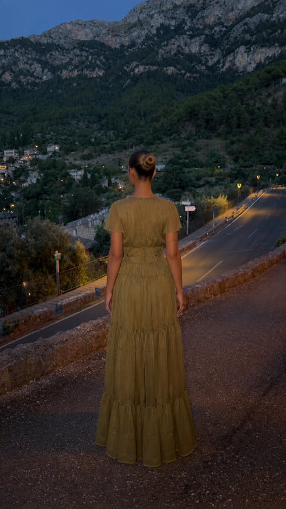 Back view of olive green flowy maxi dress showing tiered skirt silhouette