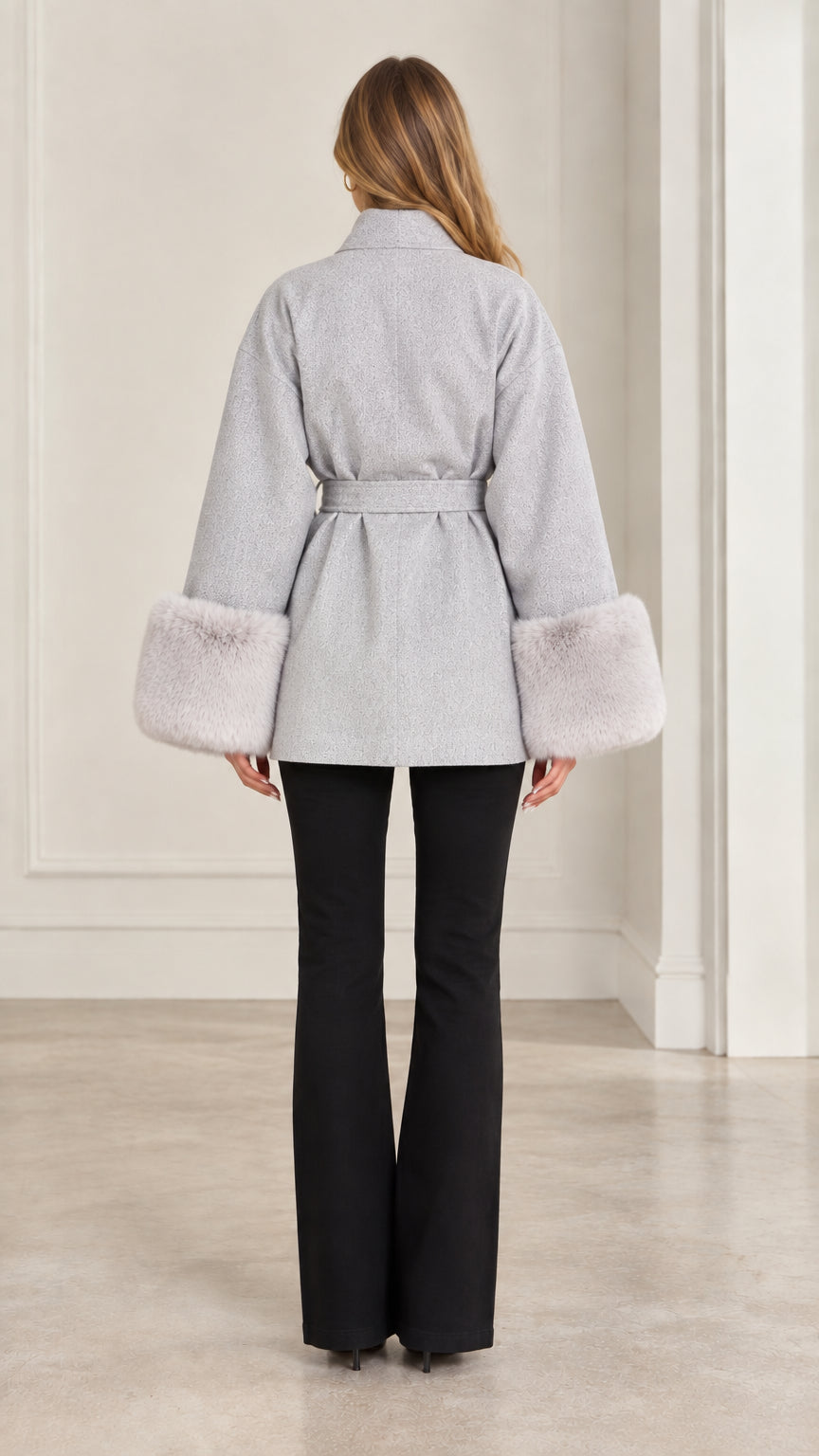Back view of model wearing grey short wrap coat with waist tie