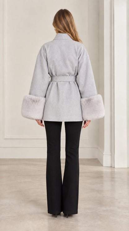 Back view of model wearing grey short wrap coat with waist tie