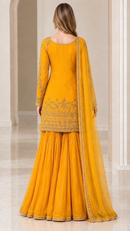 Back view of woman in Mustard Yellow embroidered sharara suit and sheer dupatta