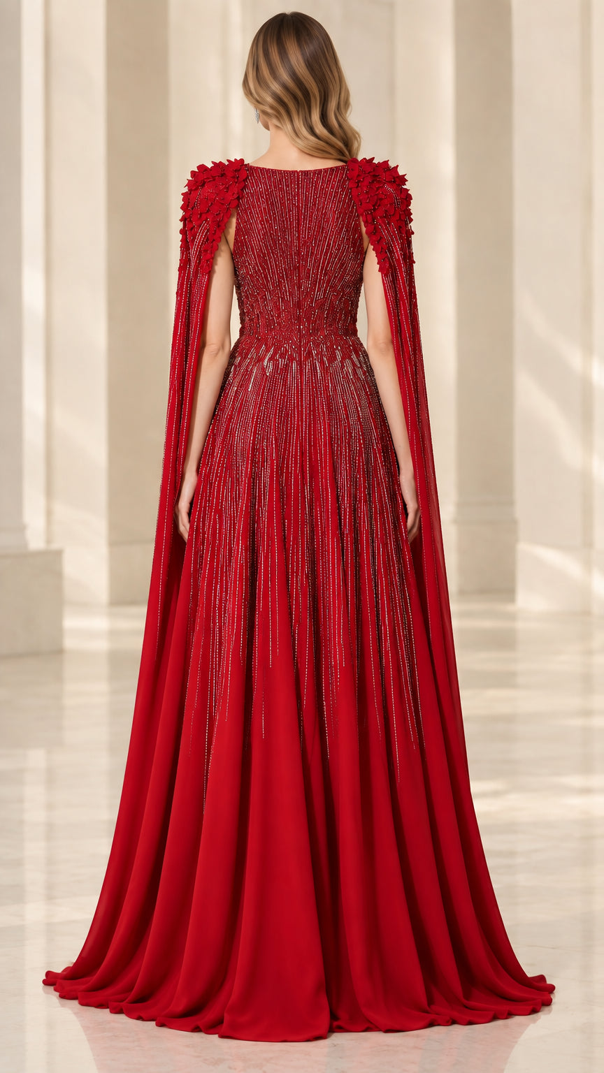 Back view of red cape evening gown with linear beadwork and flowing cape panel