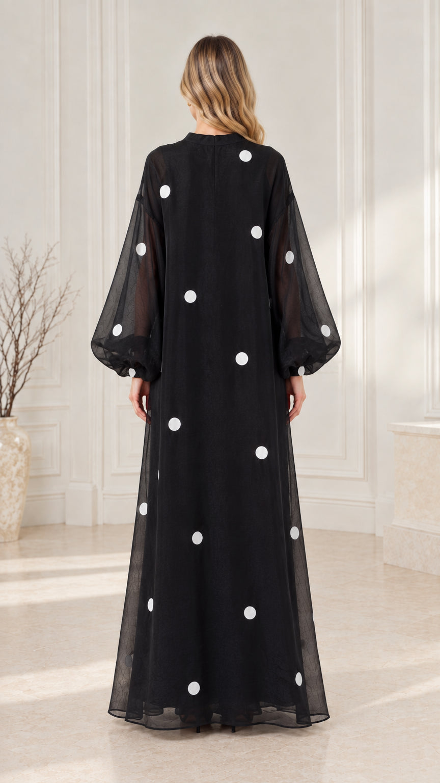 Back view of black flowing polka dot maxi dress