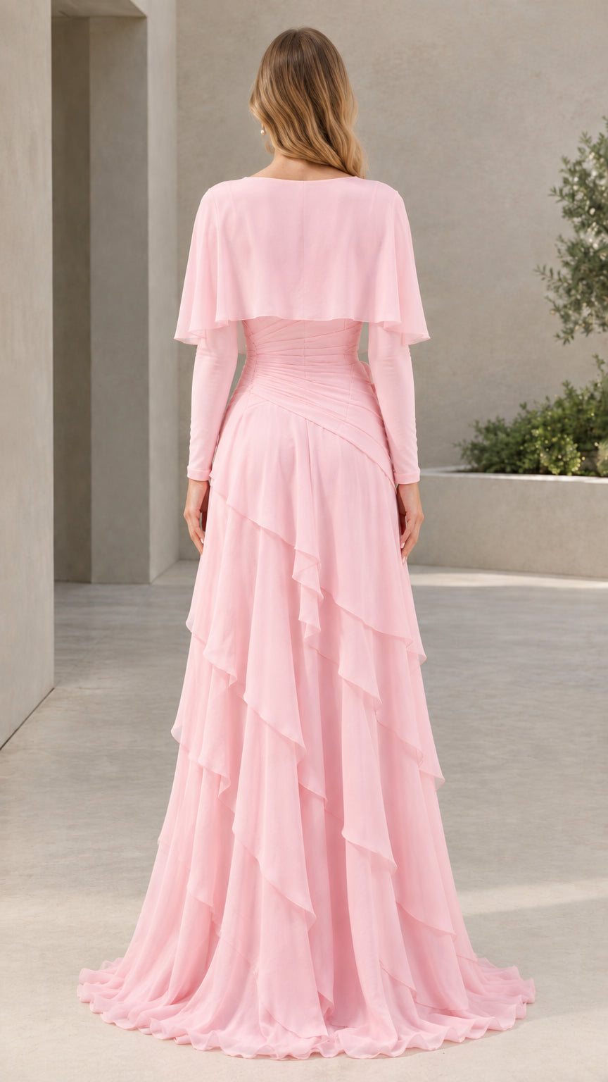 Back view of woman in Light Pink tiered ruffle chiffon maxi dress with capelet