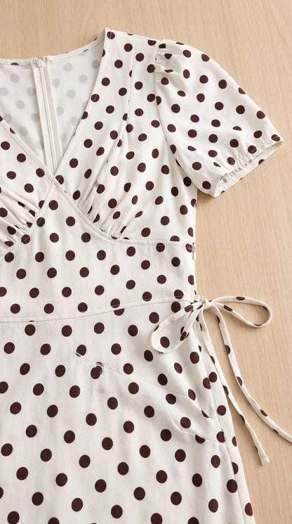 Close-up detail of neckline, bodice ruching, and side tie on polka dot dress