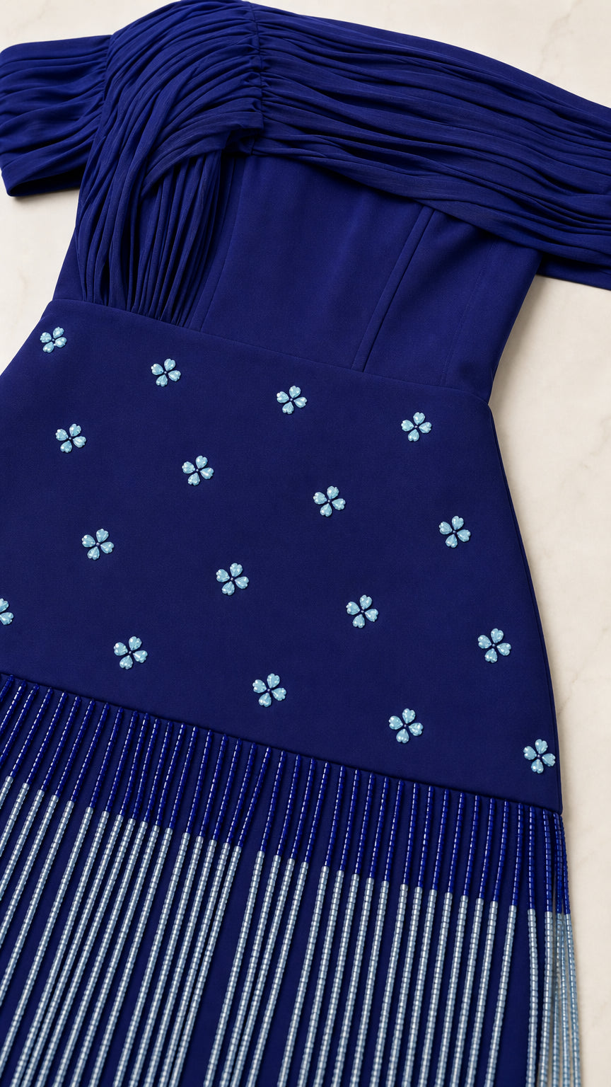 Close-up detail of pleated neckline, beaded floral motifs, and linear fringe on Royal Blue gown