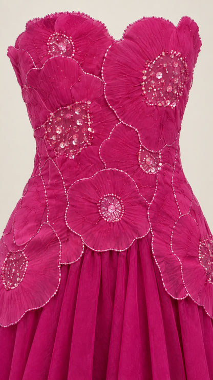 Close-up detail of beaded 3D petal embellishments on magenta dress bodice