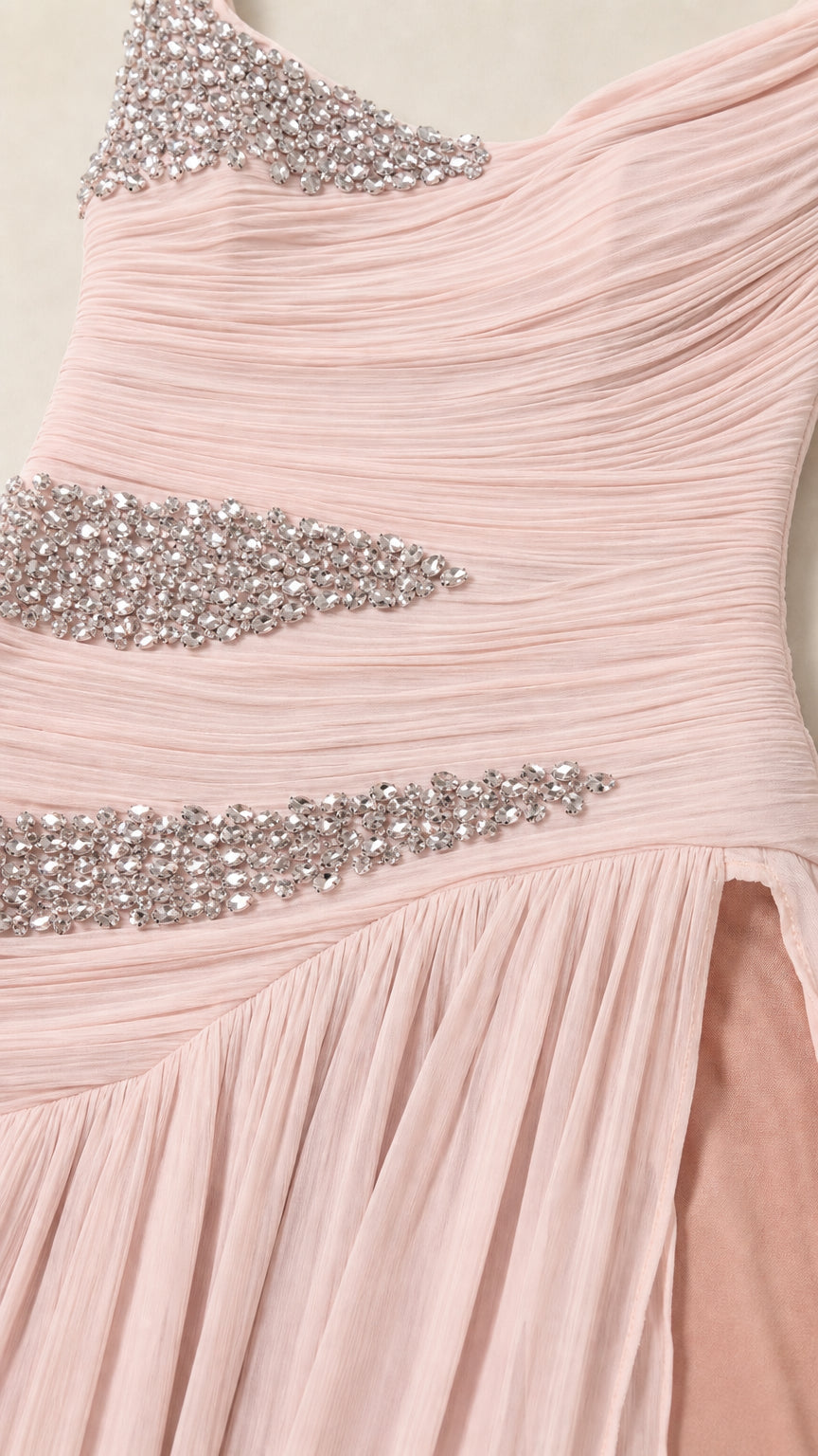 Close-up detail of delicate pink ruched chiffon fabric and sparkling rhinestone embellishments