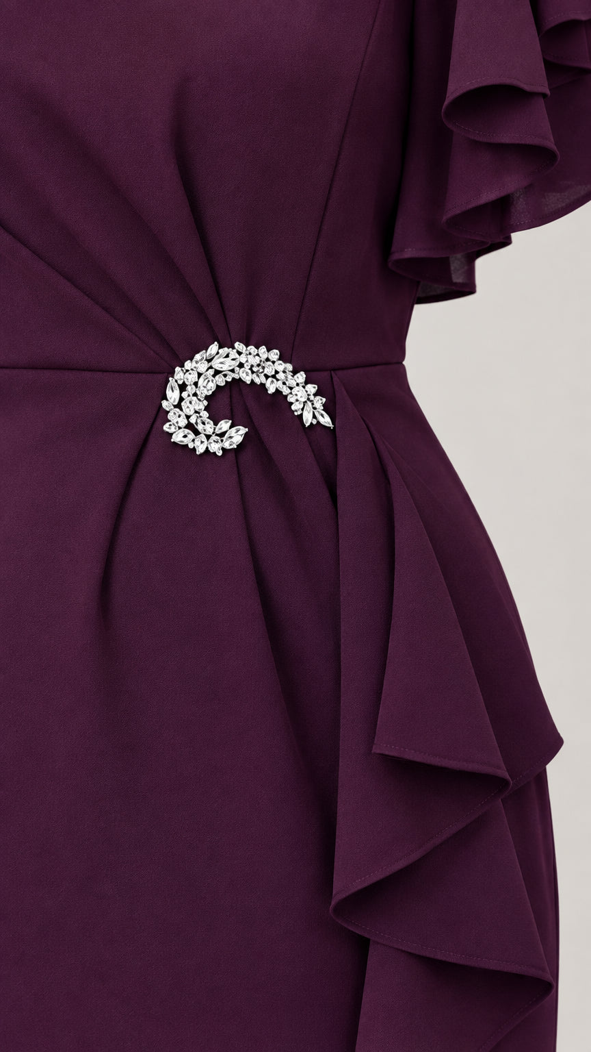 Close-up detail of waist gathering with sparkling crystal brooch accent on Plum dress