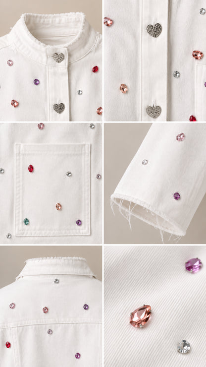 Close-up details of multicolored rhinestones, heart-shaped buttons, and raw frayed hems on white twill fabric