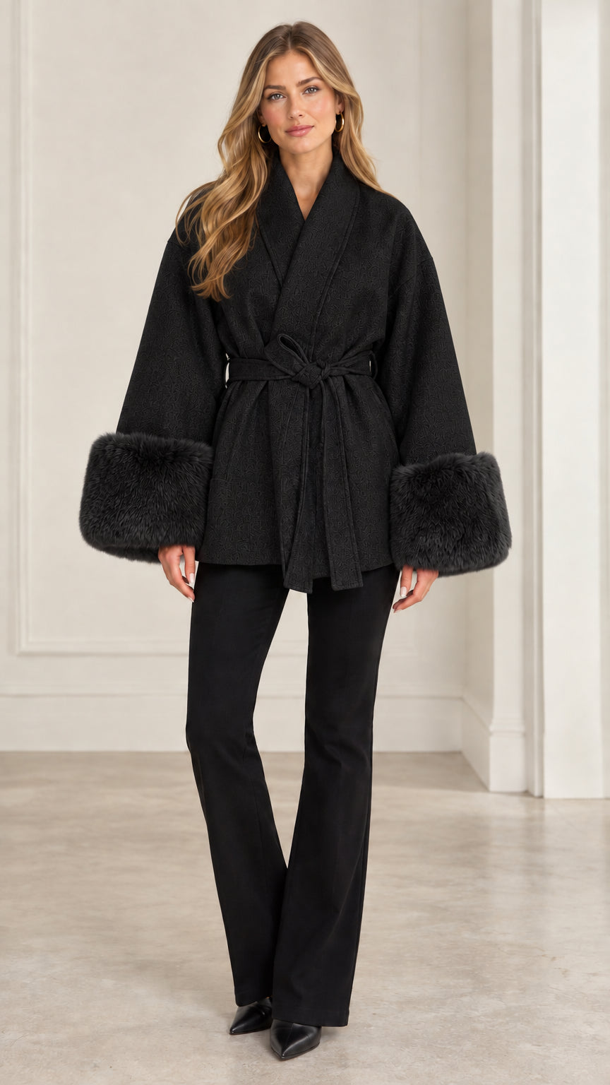 Front view of model wearing black belted faux fur cuff wrap coat