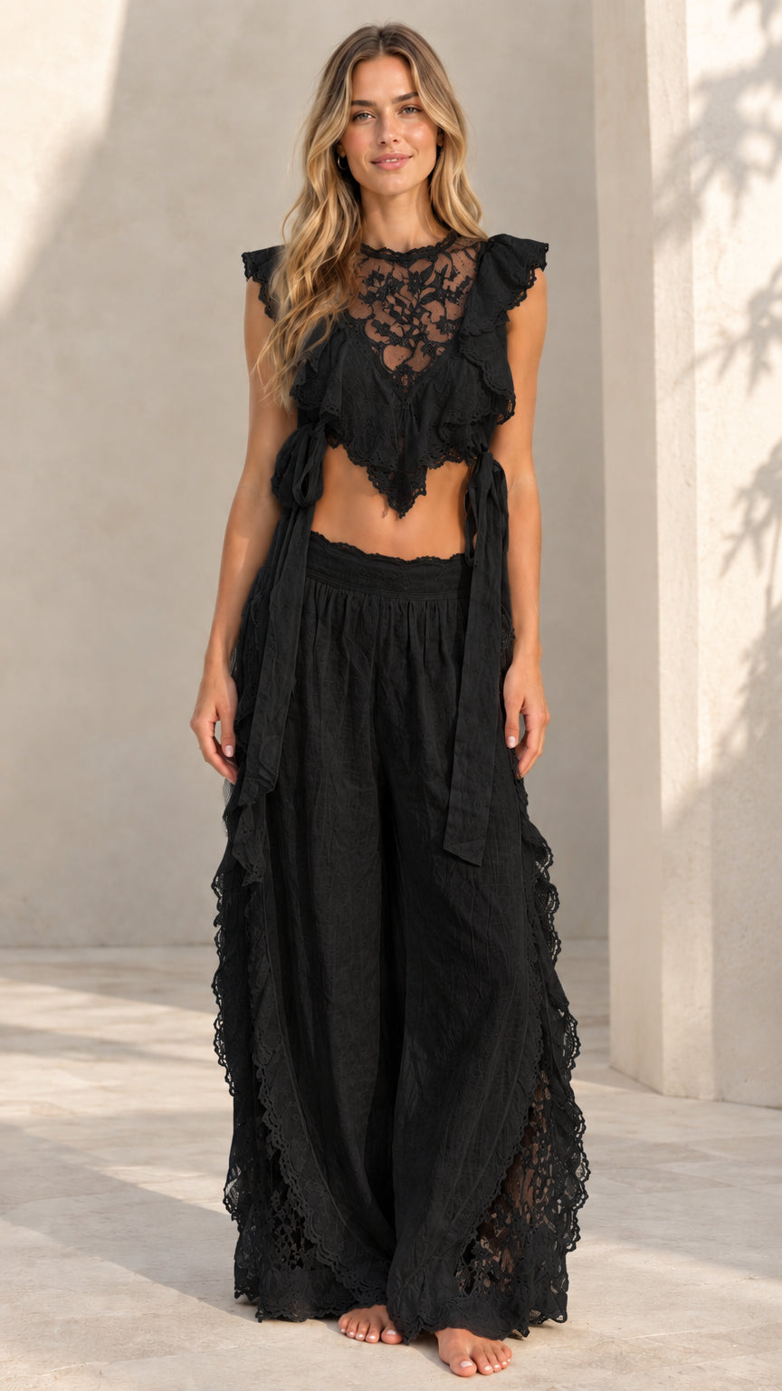 Woman wearing black lace ruffle crop top and matching wide-leg palazzo pants