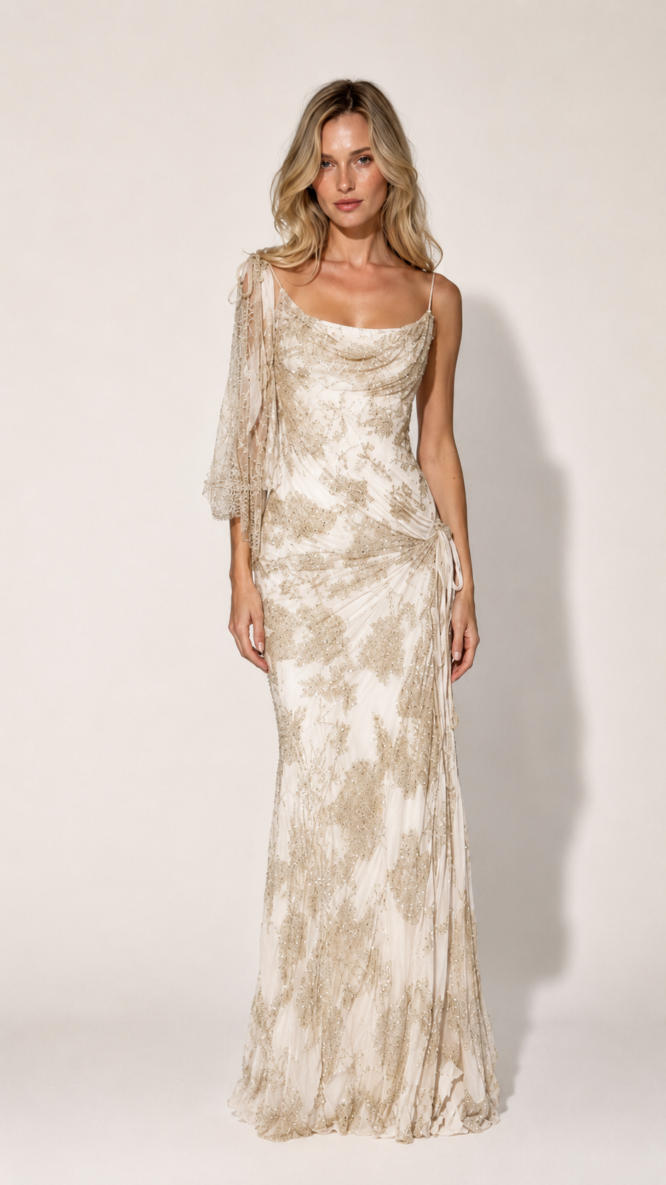 Front view of ivory one-shoulder draped formal gown with gold-toned shimmer pattern
