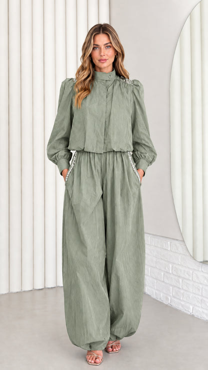 Front view of model wearing sage green embellished high-neck jumpsuit