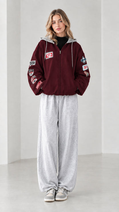 Front full view of burgundy wine zip-up hooded bomber jacket with sleeve patches